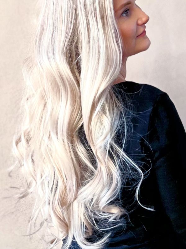 Luxurious long hair styled into soft, voluminous curls at Niki Newd® Hair Studio – timeless elegance with natural shine and movement.